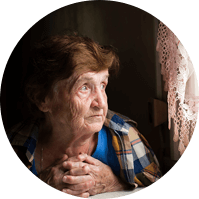 Una anciana mira por la ventana.